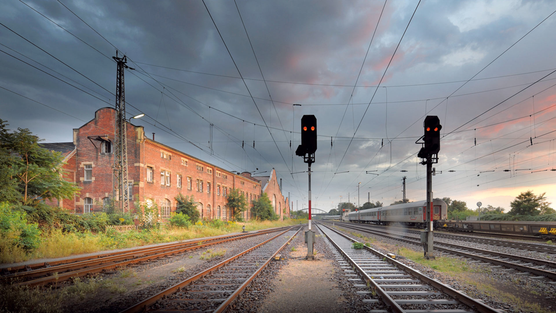 Historisches Industriegebäude neben mehreren Bahngleisen für Güterverkehr