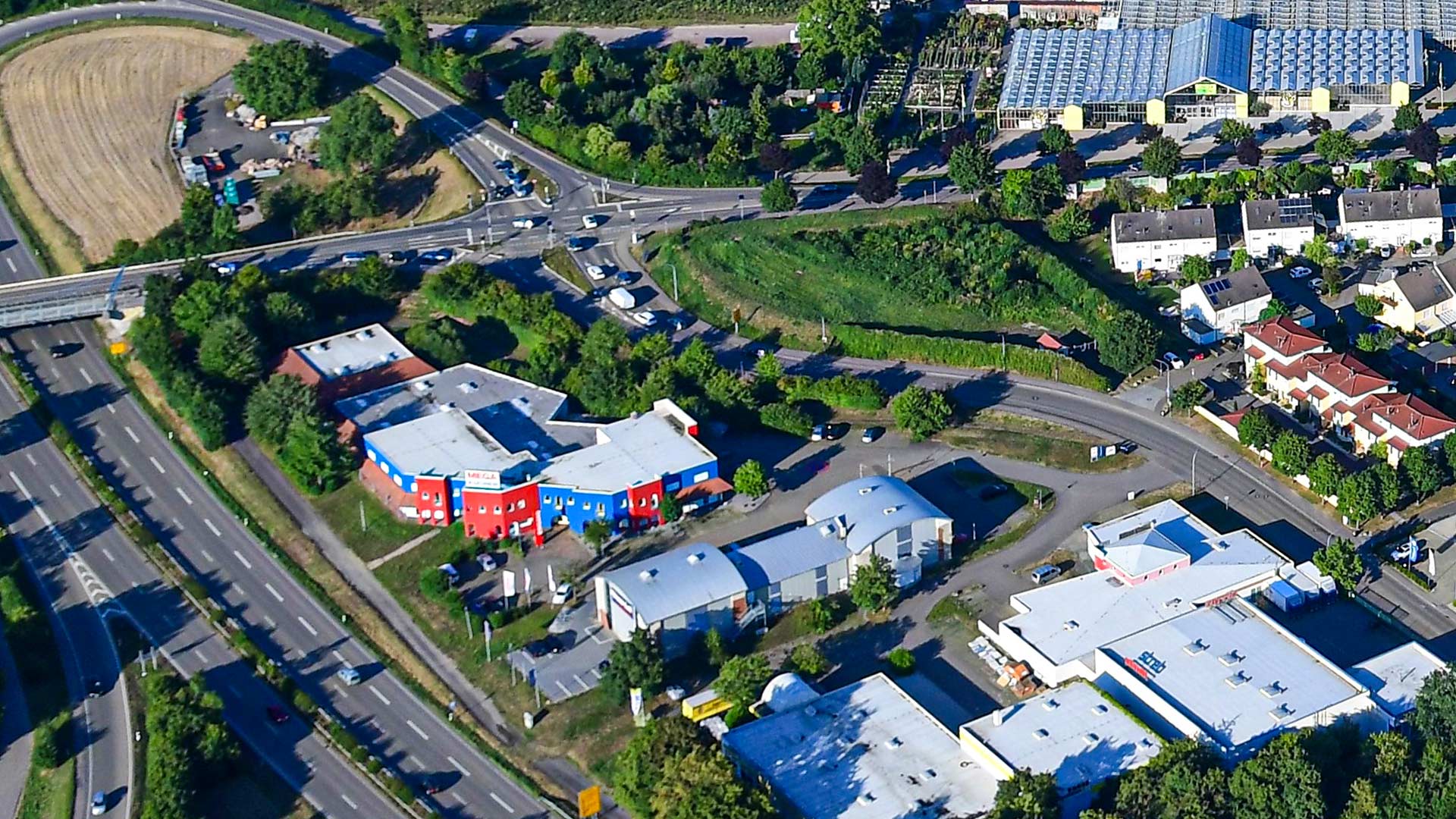 Luftansicht auf ein Gewerbeimmobilienkomplex an einer großen Straße