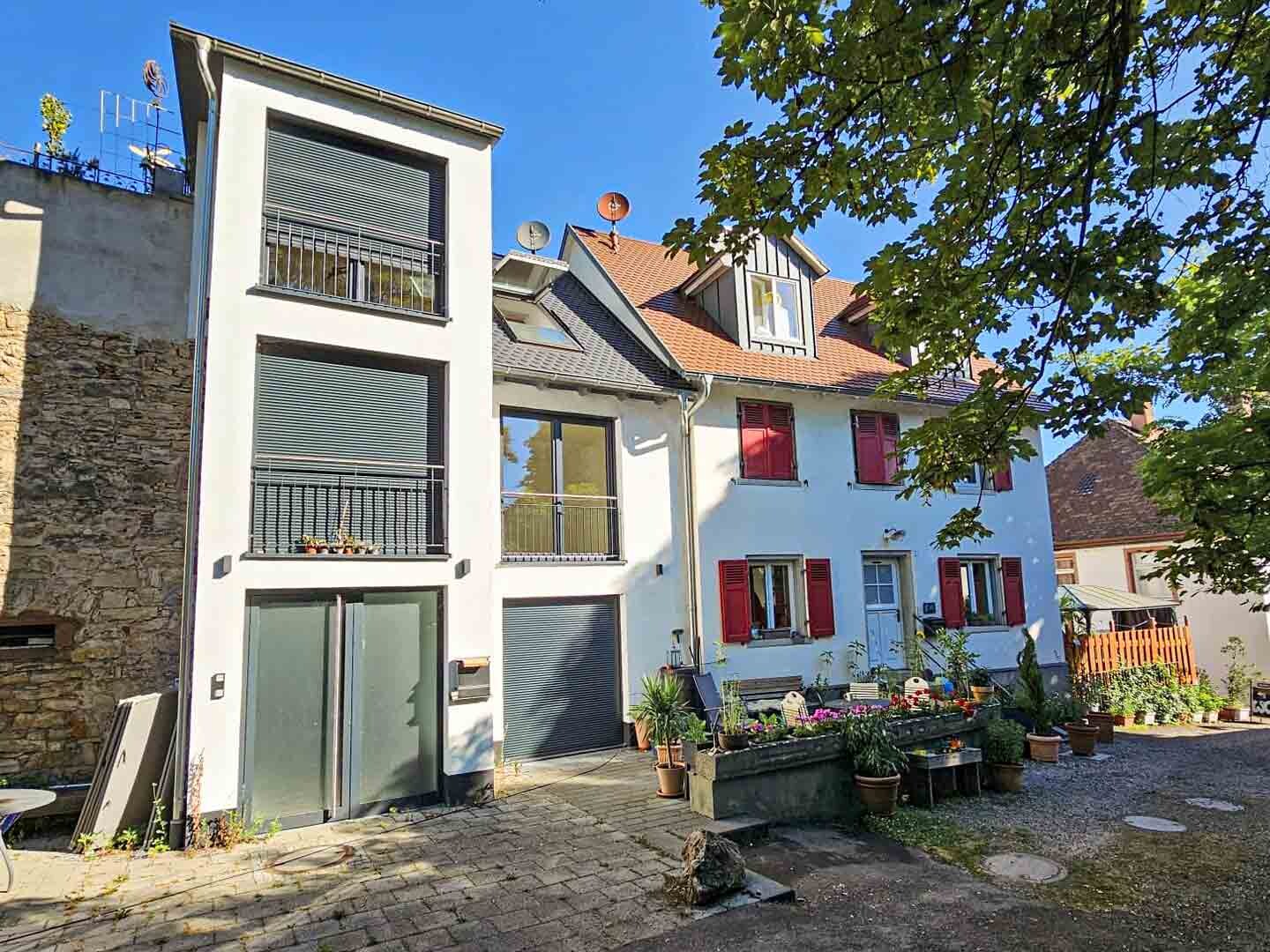 Ansicht auf ein weisses Gebäude an einer Steinmauer mit Innenhof