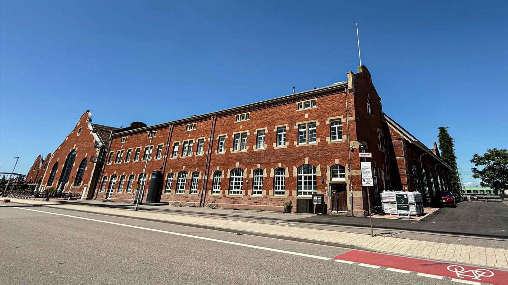Ein saniertes historisches Bahnhofsgebäude mit drei Stockwerken