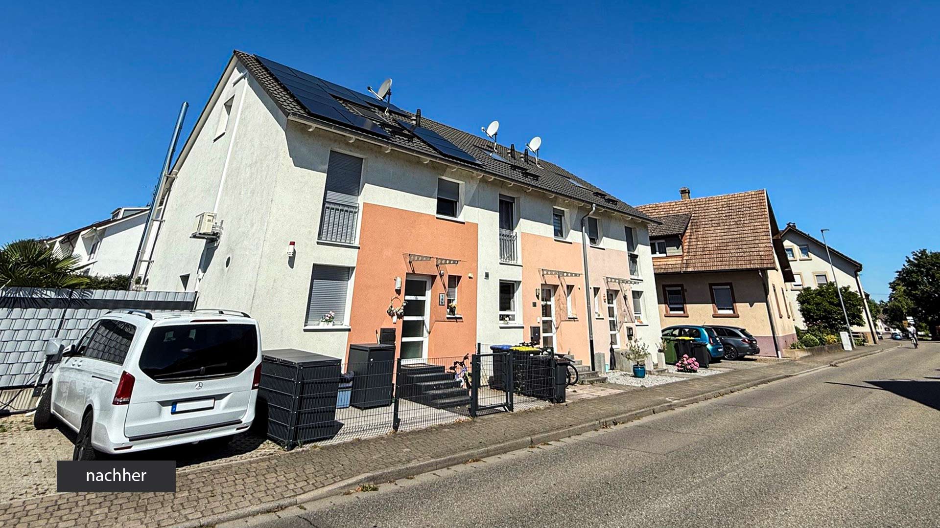 Sicht auf ein Neubaureihenhaus mit Parkplatz