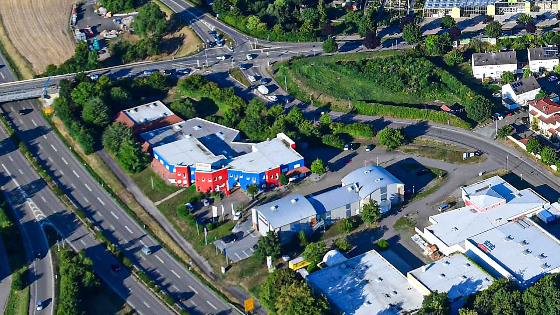 Luftansicht auf ein Gewerbeimmobilienkomplex an einer großen straße