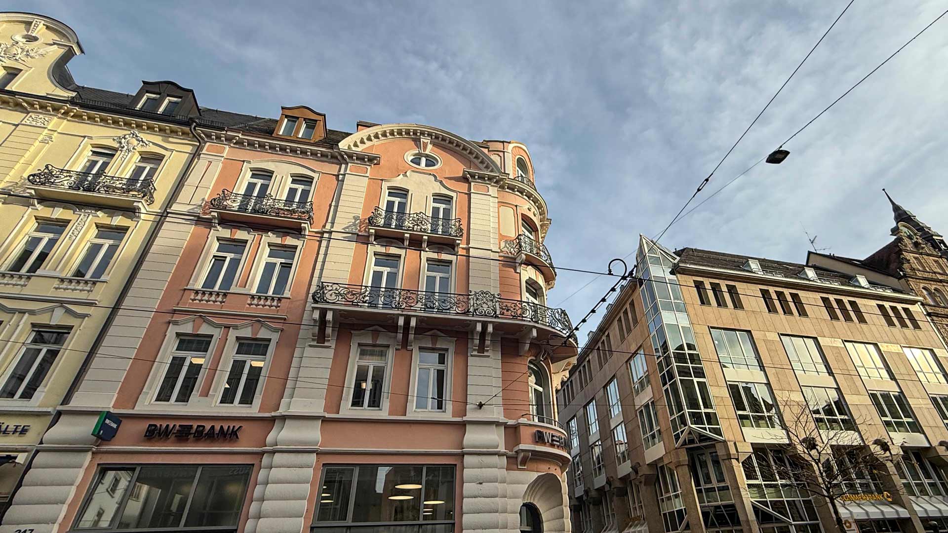 Ansicht auf ein historisches saniertes Gebäude mit rosa Wandfarbe