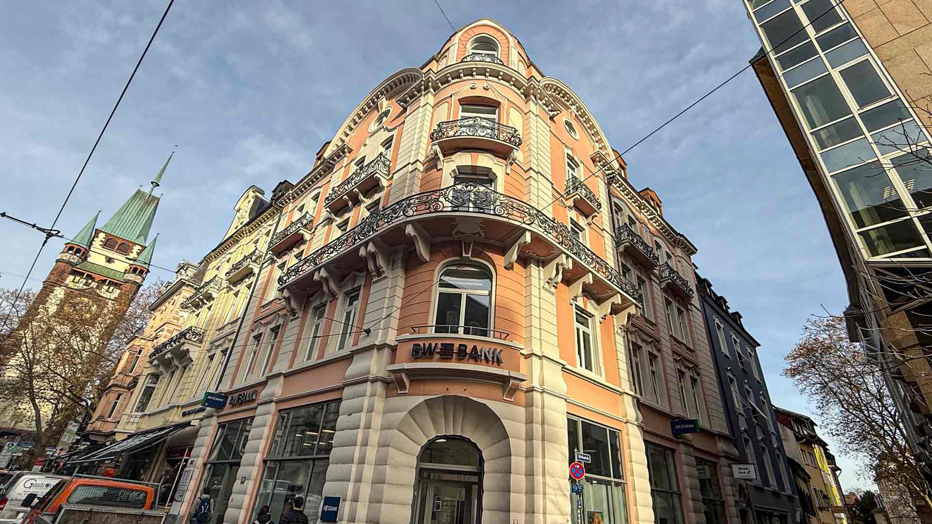 Frontalansicht auf ein historisches saniertes Gebäude mit rosa Wandfarbe