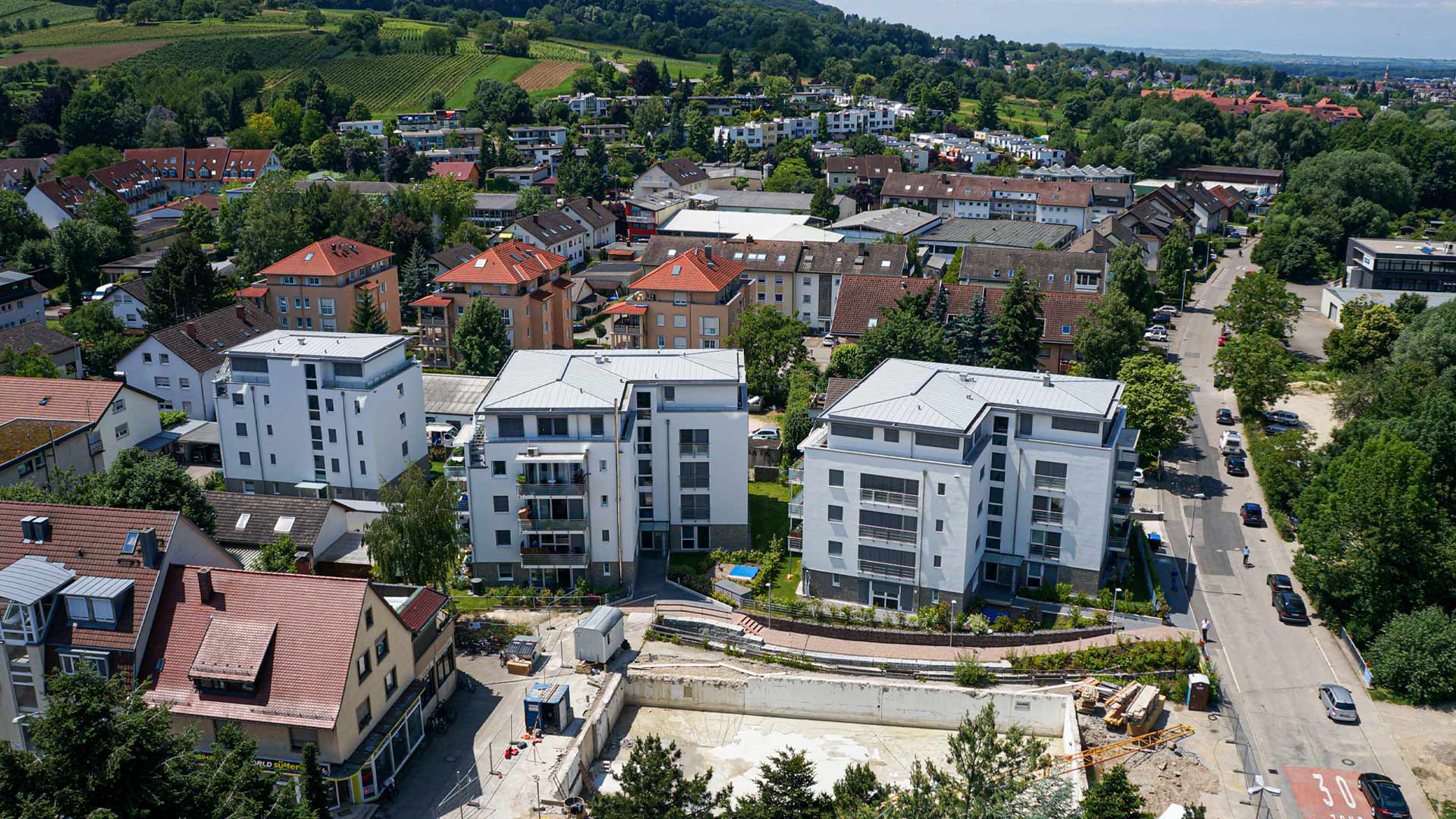 Vogelperspektive auf drei Neubau-Gebäude in einer Stadt